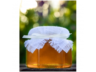 Honey jar decorated with white linen and ribbon